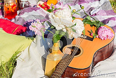 Picnic in the outdoor with guitar, pillows and peonies Stock Photo