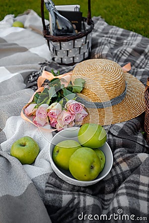 Picnic. Straw hat , apple and flowers on the lawn Stock Photo