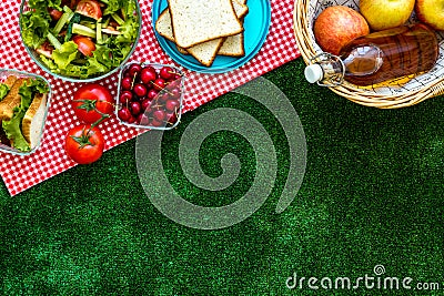 Picnic in summer with products, sandwich, salad, fruits, drink on green grass texture background top view mockup Stock Photo