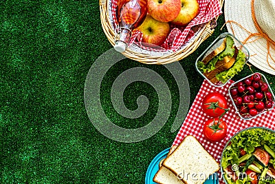 Picnic in summer with products, sandwich, salad, fruits, drink and hat on green grass texture background top view mockup Stock Photo