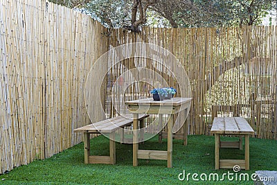 Picnic table in the village Wooden table bench wooden fence on the street on green grass Stock Photo