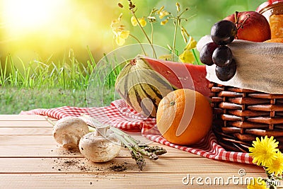 Picnic wicker basket with food on table in field closeup Stock Photo