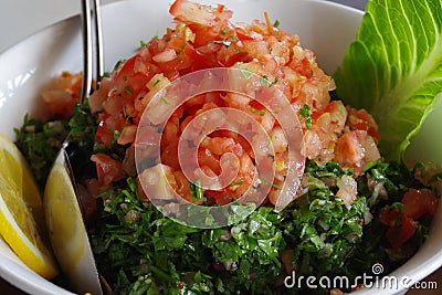 Picture of an Arabic salad, fresh tabouleh made of parsley, tomatoes, lemon juice, mint. Stock Photo