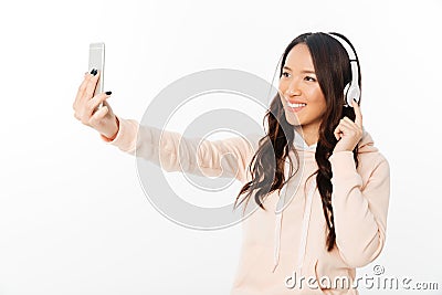 Asian cheerful woman listening music make selfie by mobile phone. Stock Photo