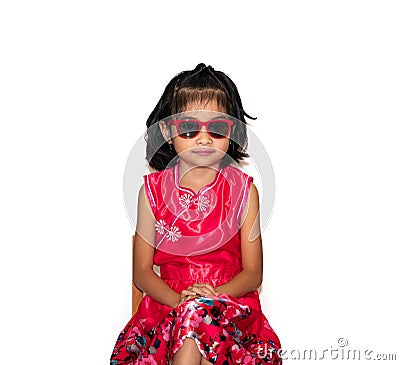 Picture of beautiful liitle girl in red chinese dress wearing sun glasses sitting on chair Stock Photo