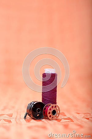 Picture of bobbin case, bobbin and thread on the orange cloth Stock Photo