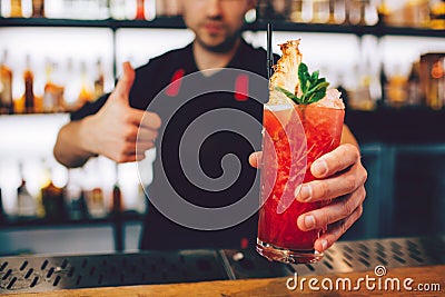 A picture of cocktail that is pepared by barman. It has nice red color. Also there is some ice on the top of the Stock Photo