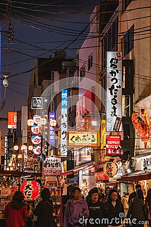 A picture of Dotonbori at night, filled with people and signs advertising shops. Editorial Stock Photo