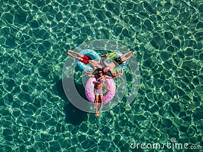 Picture with drone of people, floating on inflatable colorful rings in the sea Stock Photo