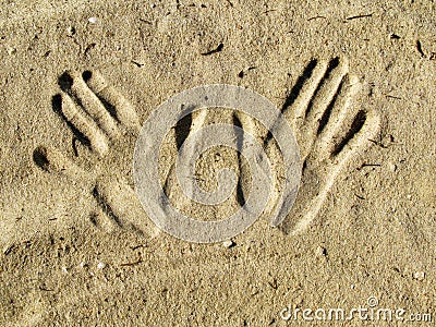 Drawing of the hands on the sand. Stock Photo