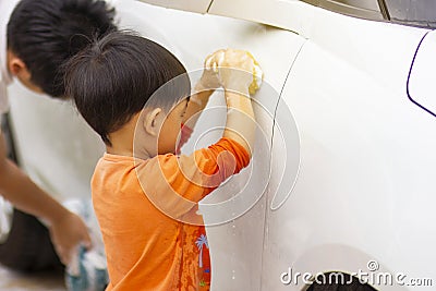Happy child being a little helper by helping her daddy cleaning up the car. Stock Photo