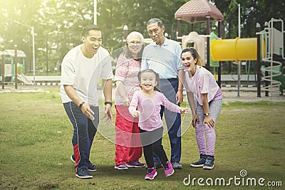 Happy little girl plays with her family in the park Stock Photo