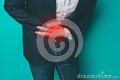 A picture of man that has a pain in stomach. He is holding both hands on the place where the pain is. That place is Stock Photo