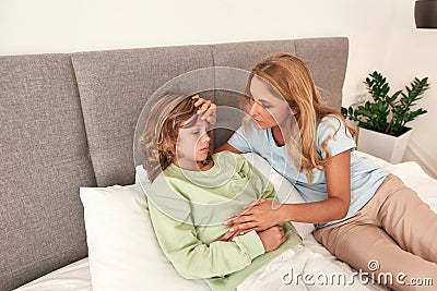 A picture of a mother checking her sons fever Stock Photo