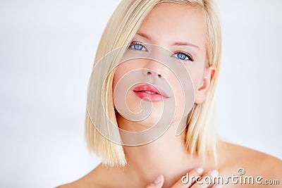 The picture of natural beauty. Poised young woman touching her skin against a white background. Stock Photo