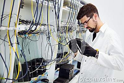 Picture of network technician testing modems in factory Stock Photo