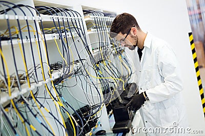 Picture of network technician testing modems in factory Stock Photo