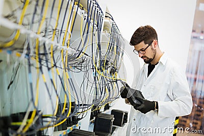 Picture of network technician testing modems in factory Stock Photo