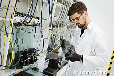 Picture of network technician testing modems in factory Stock Photo