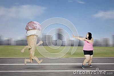 Obese woman escaping from an ice cream Stock Photo