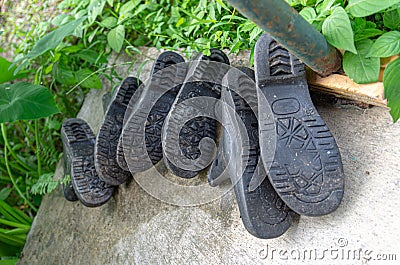 Picture of a 3 pair of rubber boots in the garden Stock Photo