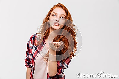 Picture of Pleased ginger woman in shirt sends air kiss Stock Photo