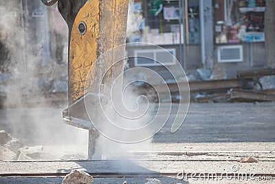 Jackhammer mounted on a renovation vehicle, with a pneumatic drill perforating the asphalt of an urban road being renovated Stock Photo