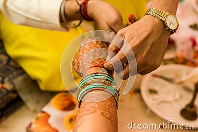 Hindu priest tying a thread on a woman`s hand. Stock Photo