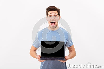 Picture of satisfied bearded man holding silver notebook demonstrating or advertising copyspace screen, isolated over white wall Stock Photo