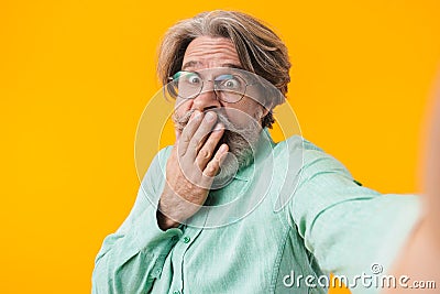 Shocked grey-haired man take a selfie by camera Stock Photo