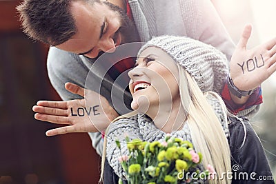 Picture showing young couple with flowers dating in the city Stock Photo