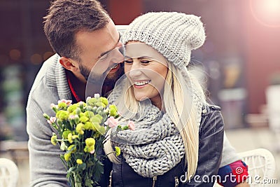 Picture showing young couple with flowers dating in the city Stock Photo