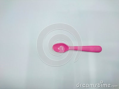 The picture shows a pink spoon plastic on a white background. Stock Photo