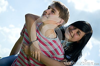 Picture of teenage boy and girl embracing over sky Stock Photo