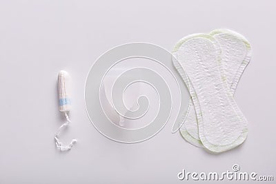 Picture of various kinds of products for menstruation. Hygiene pads, white menstrual cup and tampon lying on white surface. Stock Photo