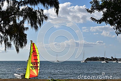 Picture of a water bay in Mauritius with in the foreground a very colorful sail of a Hobie Cat, a very famous small and fast saili Editorial Stock Photo