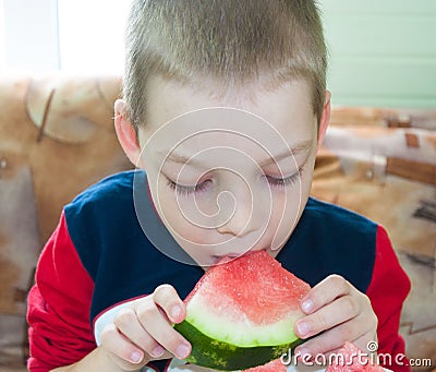 Picture of young boy and a slice of watermelon with big bite marks Stock Photo