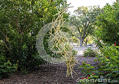 Abstract sculpture with many small yellow pipes tangles and suspended, appearing to defy gravity in Dallas Stock Photo