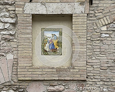 Art piece featuring Mary, Joseph, Jesus and a lamb in an outside wall niche on a street in Assisi, Italyaaly. Editorial Stock Photo