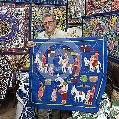 Artisan showing a piece of his work in his shop on the Street of the Tentmakers in Cairo, Egypt. Editorial Stock Photo