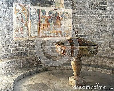 Baptismal and fresco in the Church of Santa Maria del Tiglio in Gravedona on Lake Como. Editorial Stock Photo