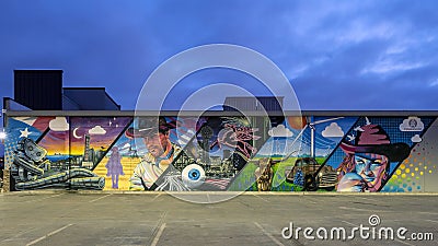 Blue hour photo of a mural featuring a mashup of Dallas city life and Texas on Sam`s Club Now in Dallas, Texas. Editorial Stock Photo