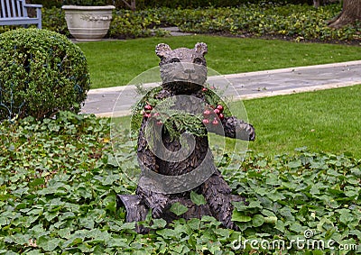 Small bronze bear with human face in a yard in Dallas, Texas Stock Photo