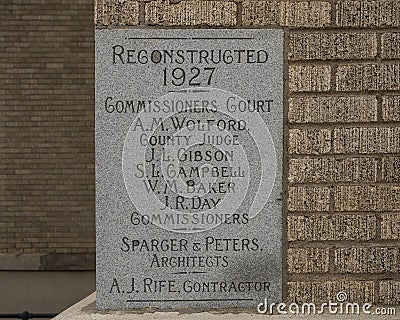 Closeup of an information plaque of engraved stone in a brick wall of the old Commissioner`s Court Building in McKinney, Texas. Editorial Stock Photo