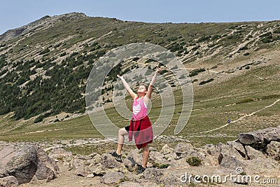 Eleven year-old Caucasian standing with arms and face uplifted to the sky along a trail in Mount Rainier National Park, Washington Stock Photo