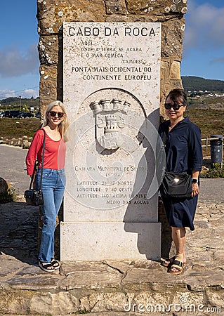 Female tourists by the Monument to Cabo da Roca being the westernmost point of Europe, on the Atlantic Ocean in Portugal. Editorial Stock Photo