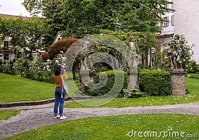 Tourist photographing sculptures in the Garden of the Atellani House, Museo Vigna di Leonardo, Milan. Stock Photo
