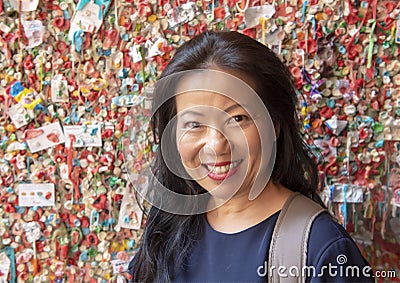 Korean woman in front of The Market Theater Gum Wall, Pike Place Market, Seattle, Washington Editorial Stock Photo