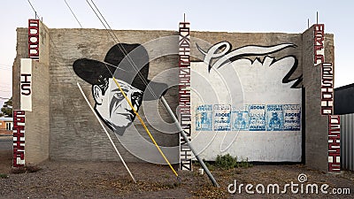 John Wayne and six `Adobe is Political` posters on a painted wall in Marfa, Texas. Editorial Stock Photo