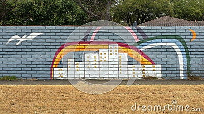 Mural on a barrier wall between Forest Lane and the neighborhood on the North side, painted in 1976 by art students. Editorial Stock Photo